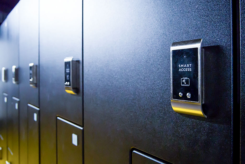 Colorful lockers of various sizes arranged in locker room, some doors slightly open, under bright, even indoor lighting.