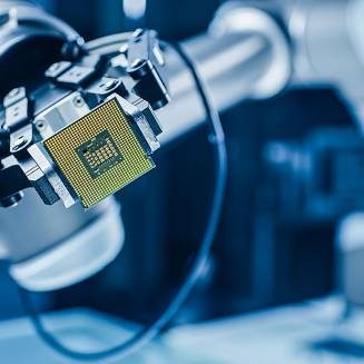 Robotic arm holding computer processor chip with golden pins, blue high-tech background blurred, precision gripping mechanism visible.